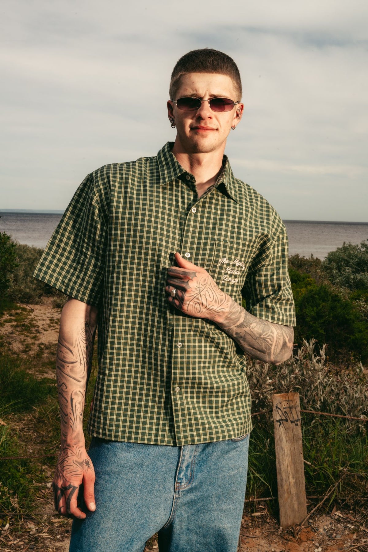Model in the green check Mystery Machine Garage button-up shirt